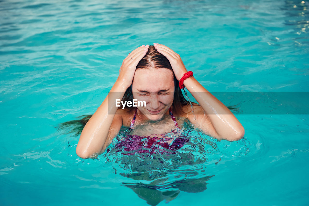 PORTRAIT OF A WOMAN IN SWIMMING POOL