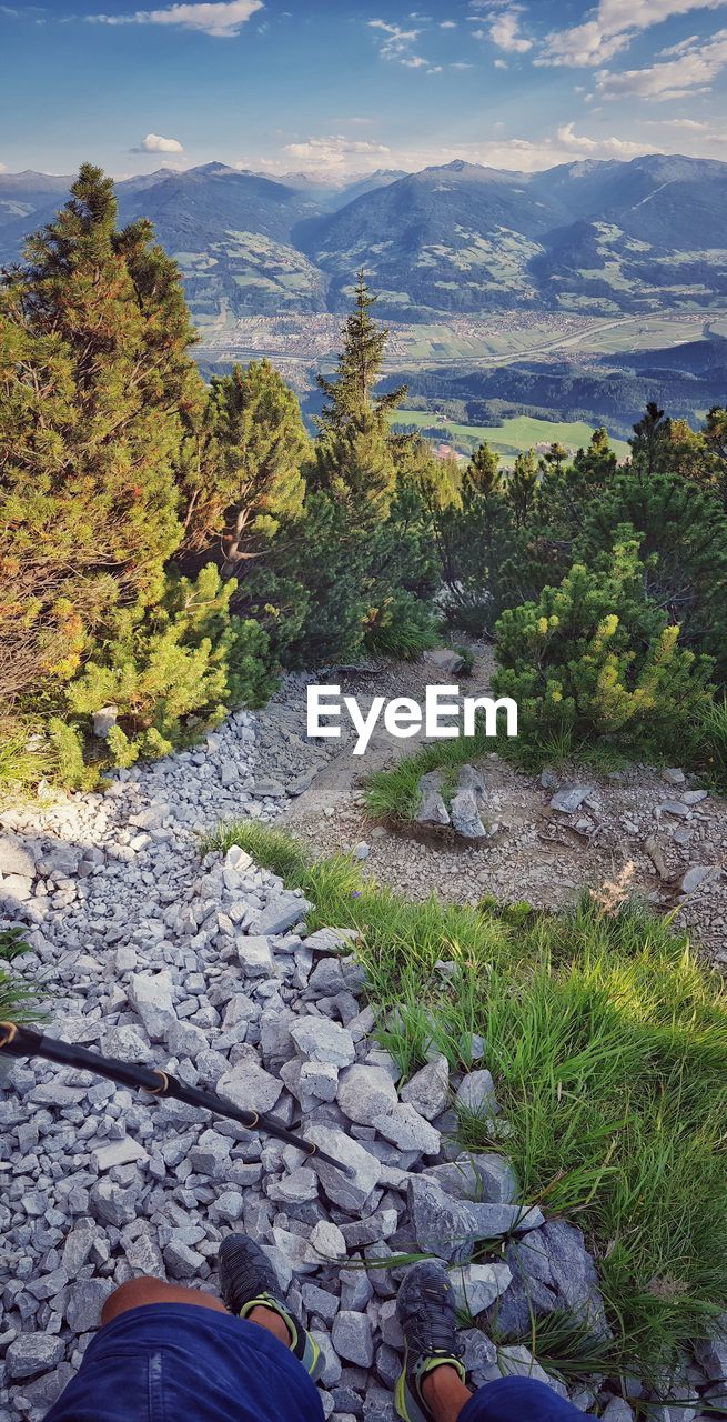 Scenic view of rocks by trees against sky