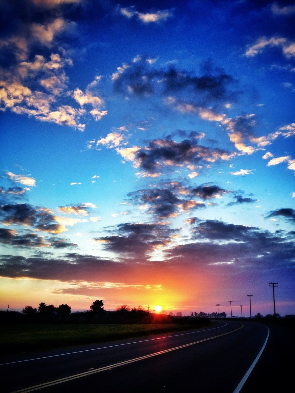 Empty road against cloudy sky