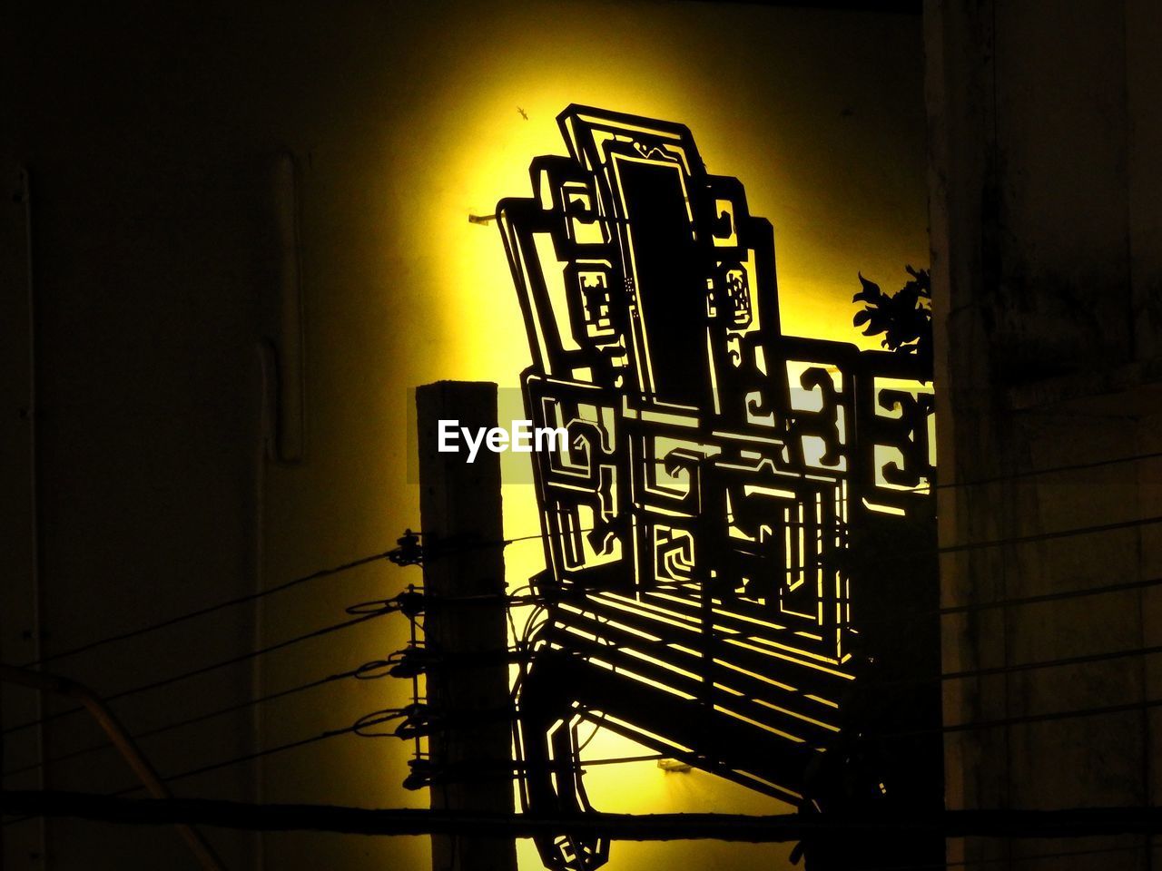 LOW ANGLE VIEW OF ILLUMINATED TEXT ON WALL AGAINST BUILDING