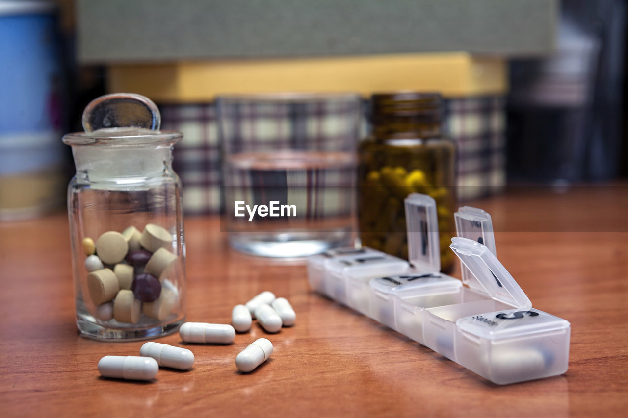 CLOSE-UP OF JAR WITH BOTTLE ON TABLE