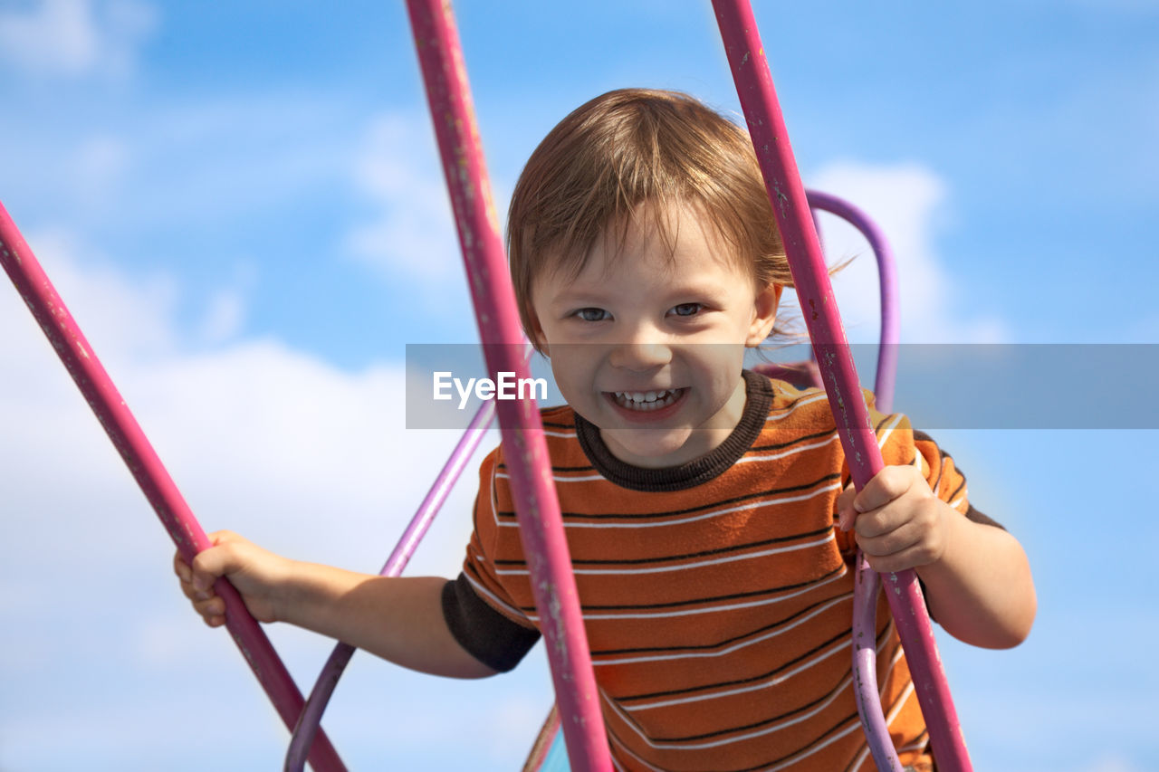 PORTRAIT OF CUTE SMILING BOY IN PLAYGROUND