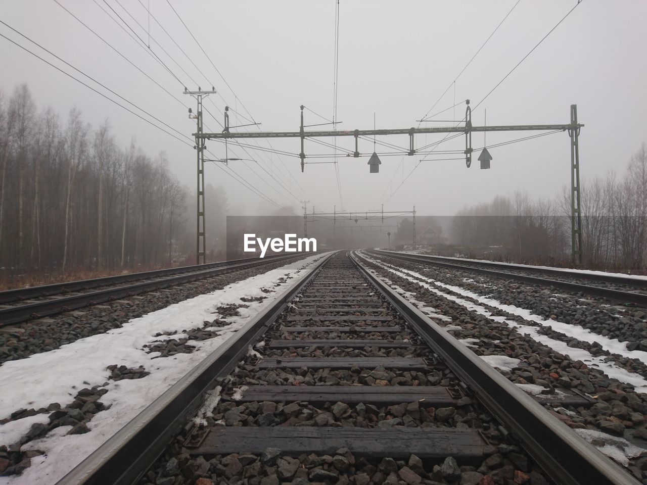 Railroad tracks against sky during winter