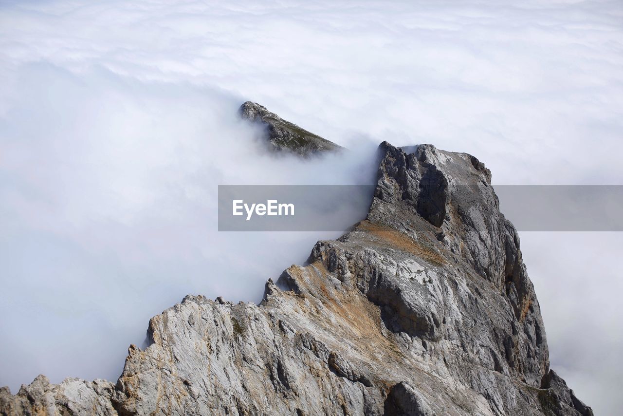 High angle view of fog over rocky mountains