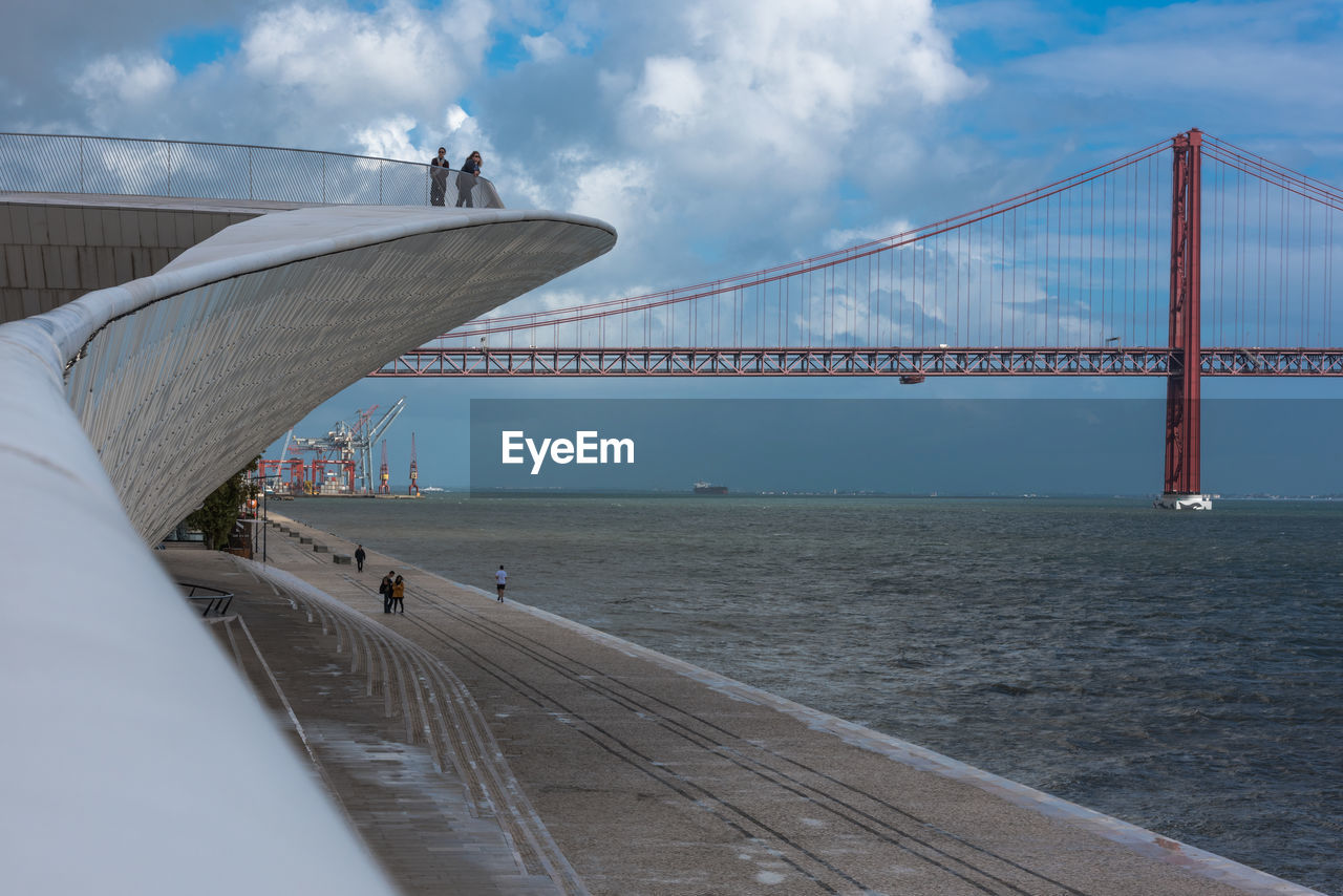 SUSPENSION BRIDGE OVER SEA AGAINST SKY