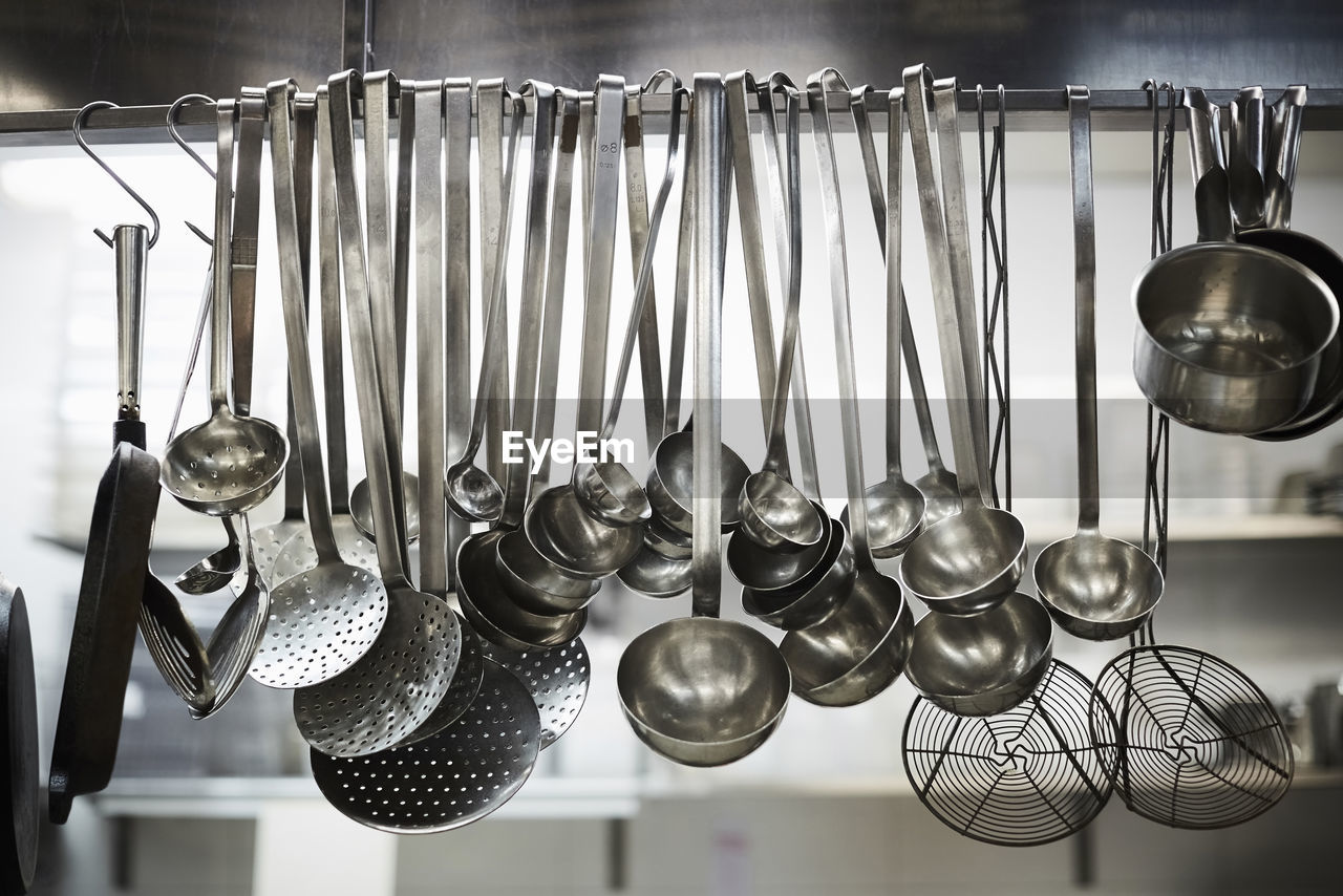 Utensils on metal rack in commercial kitchen