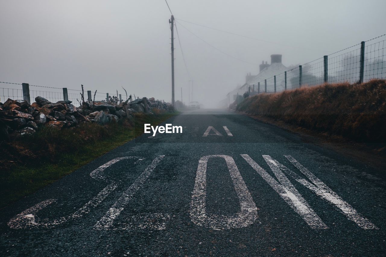 Text on road in city during foggy weather