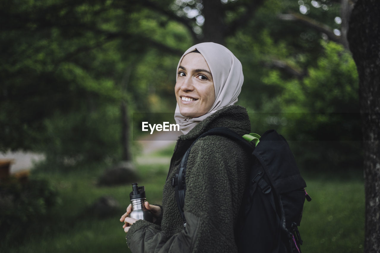 Portrait of smiling woman in hijab hiking on weekend