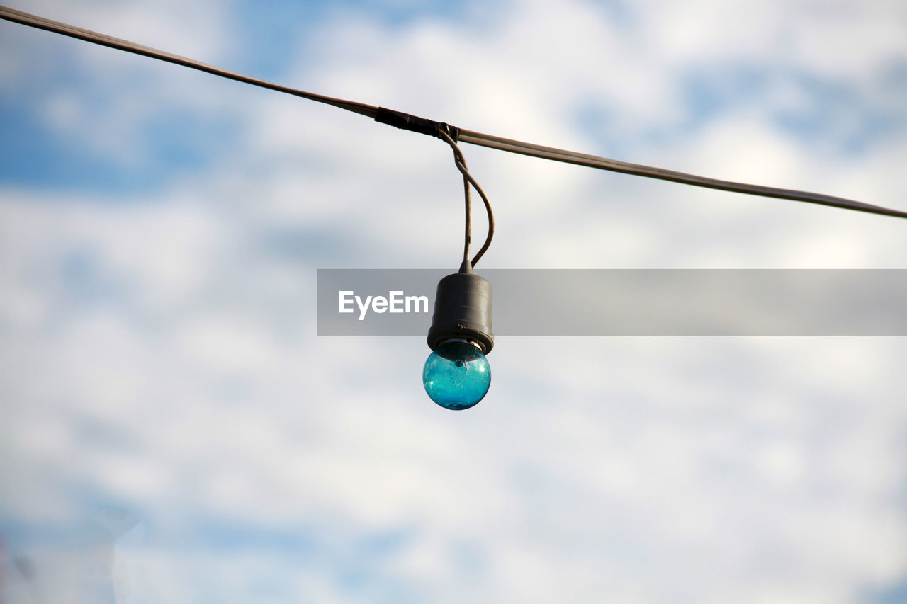 Low angle view of light bulb against sky