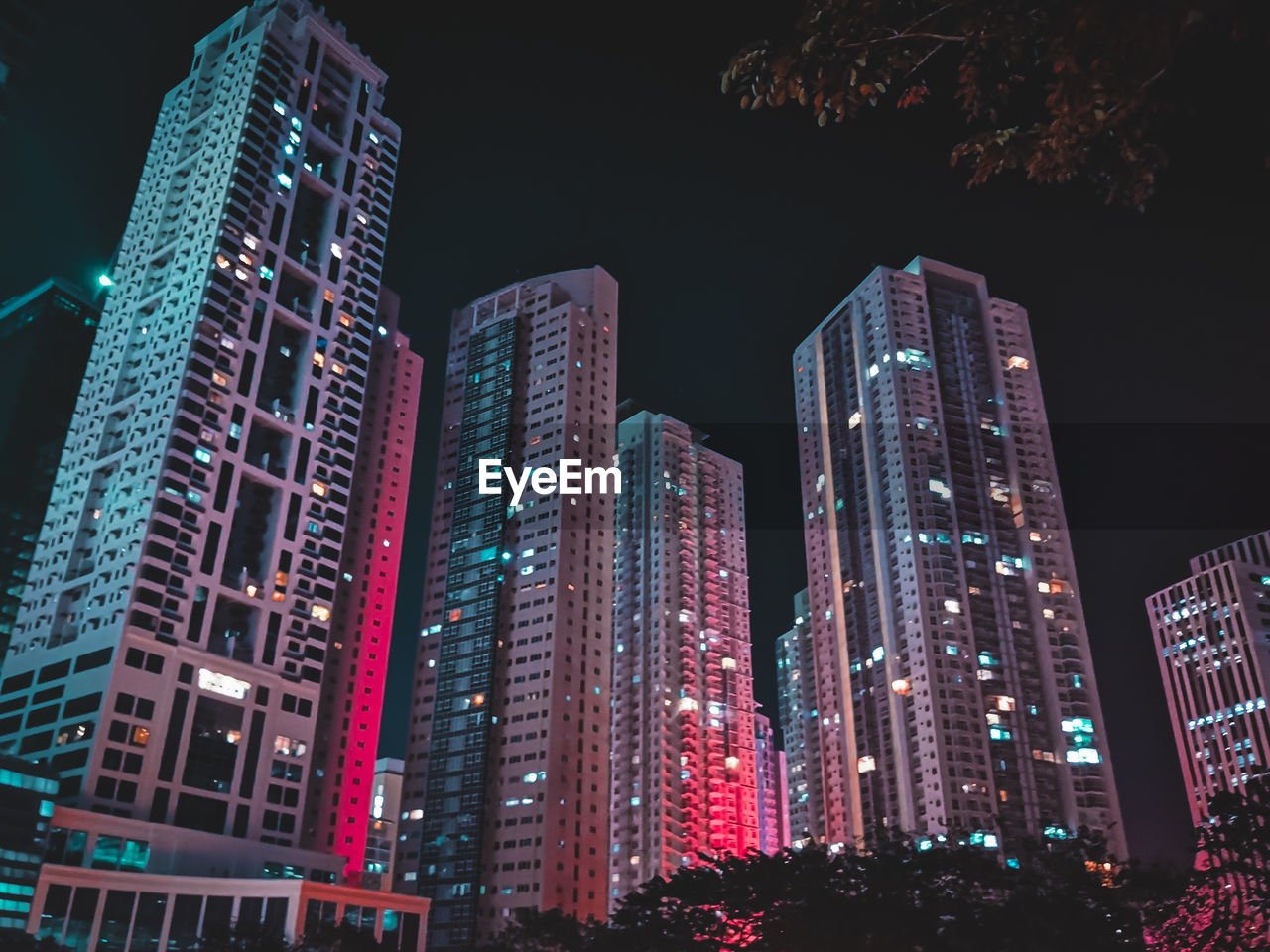 Low angle view of illuminated buildings against sky at night