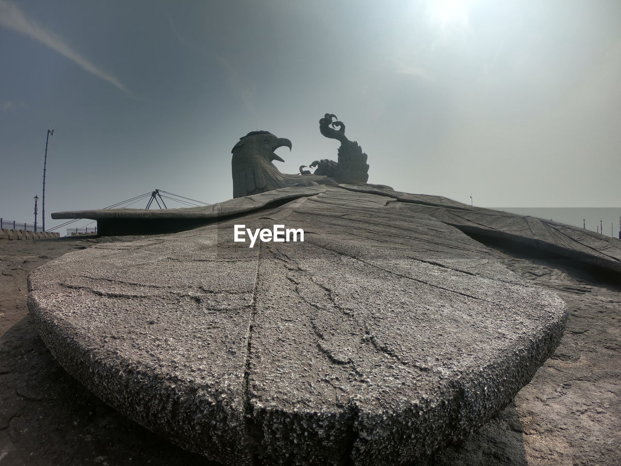 STATUE OF ROCK ON WALL AGAINST SKY