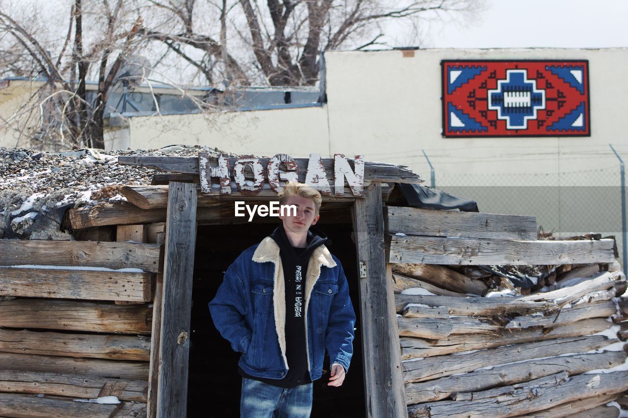 Portrait of man standing against wooden structure during winter