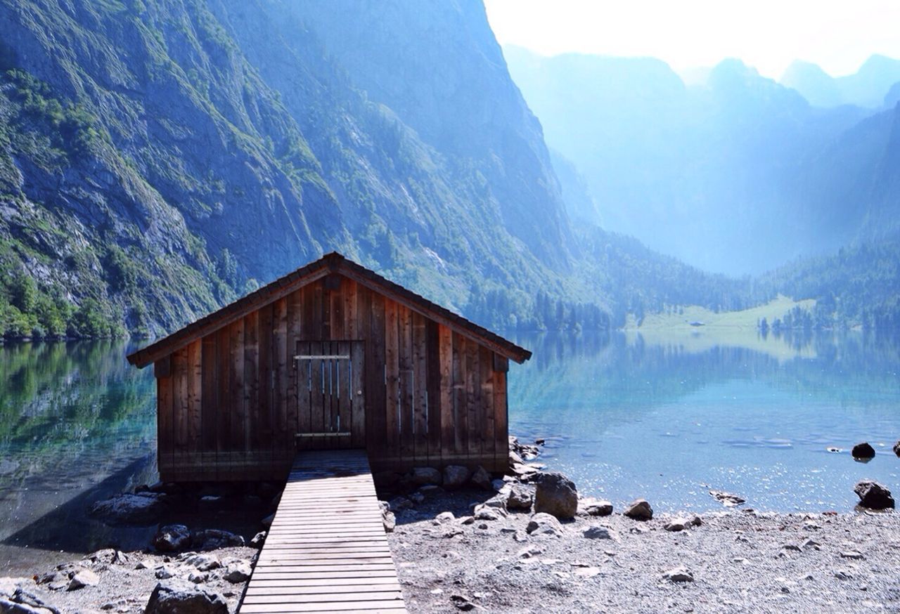 Boardwalk leading to log cabin by mountain