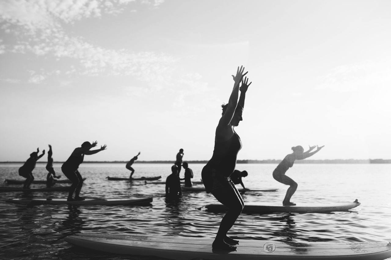 PEOPLE ON BEACH AGAINST SKY