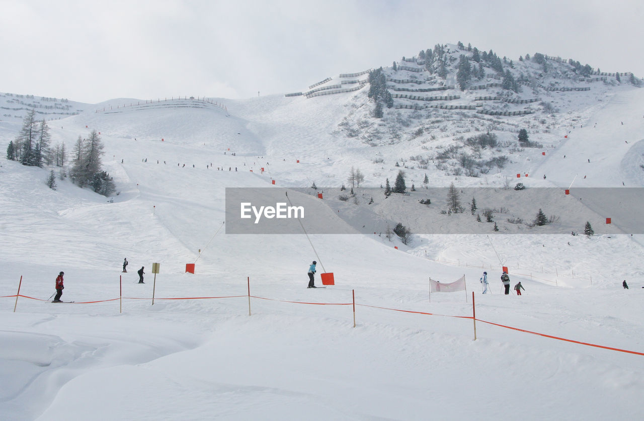 PANORAMIC VIEW OF PEOPLE ON SNOWCAPPED MOUNTAIN