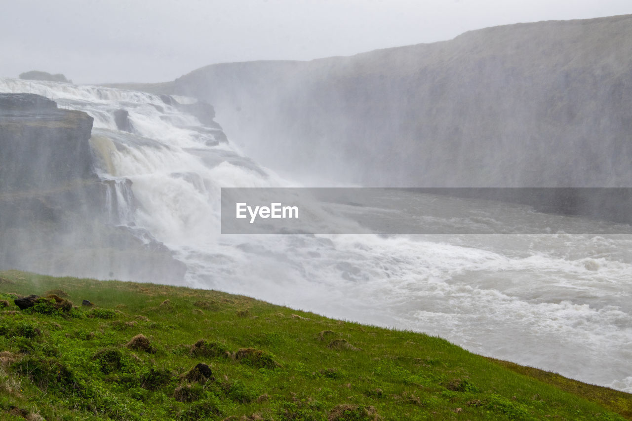 SCENIC VIEW OF SEA AGAINST MOUNTAIN