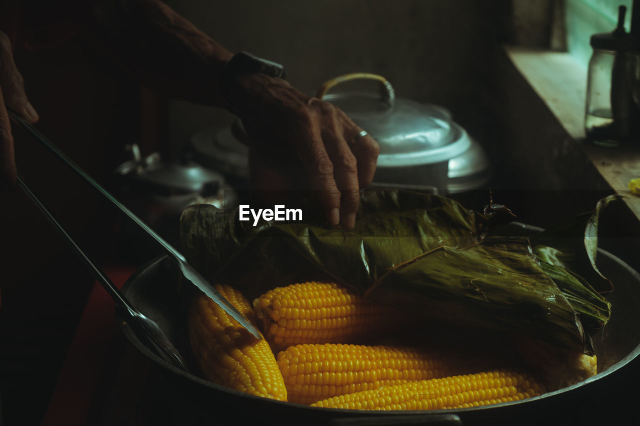 Close-up of person preparing food or corn