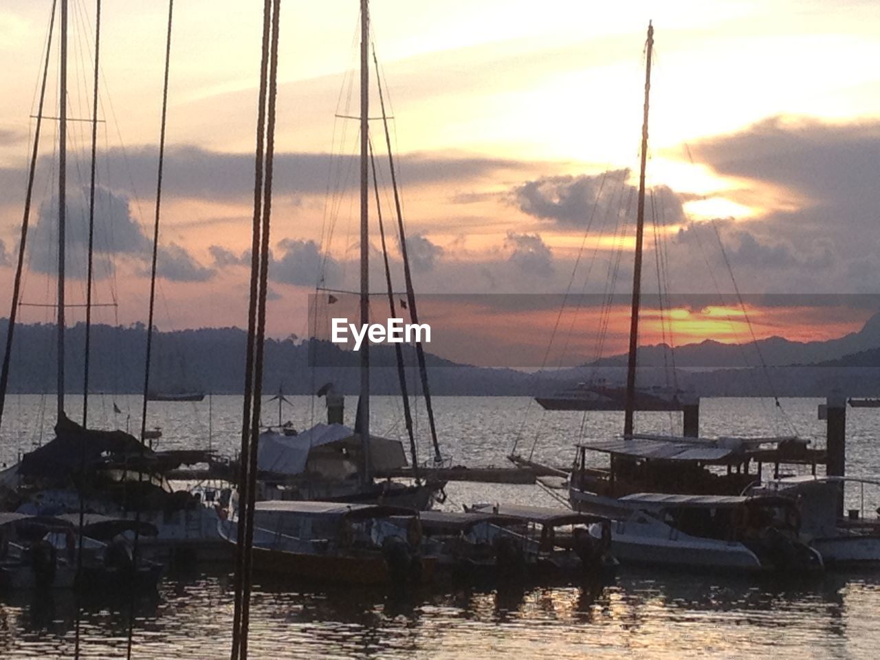 SAILBOATS IN SEA AT SUNSET