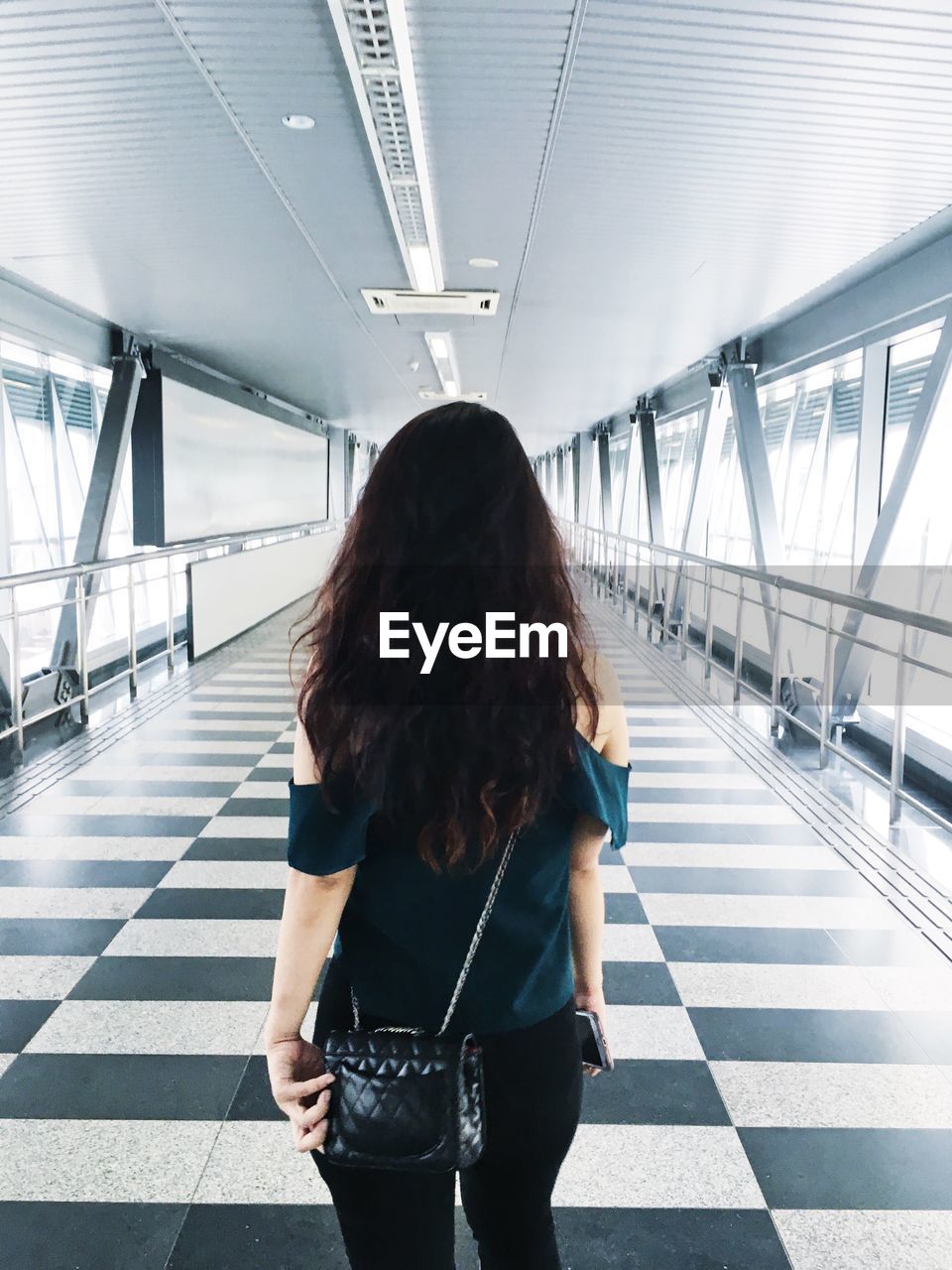 Rear view of woman standing on walkway