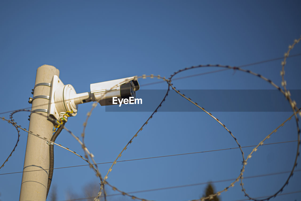 Camcorder on the fence. protected area. perimeter security. barbed wire and surveillance. 