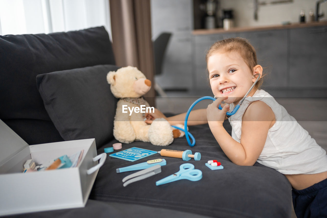 portrait of cute baby girl with teddy bear at home