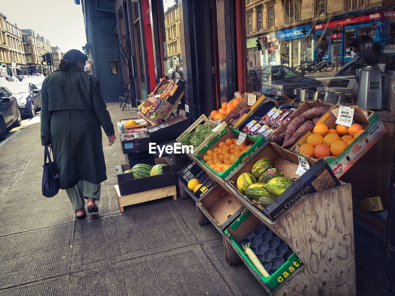 Pedestrian walking past fruit shop