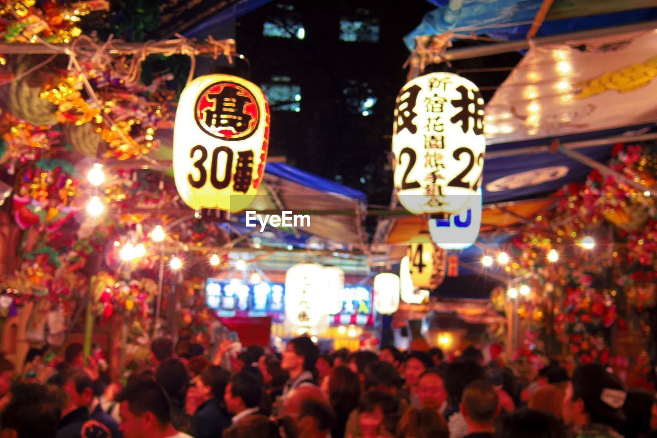 Illuminated lanterns with numbers above crowd