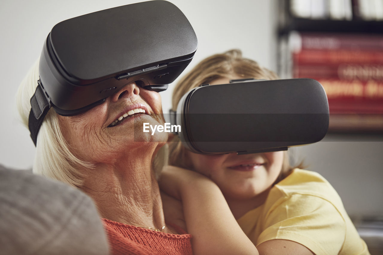 Grandmother using vr glasses with her grandson