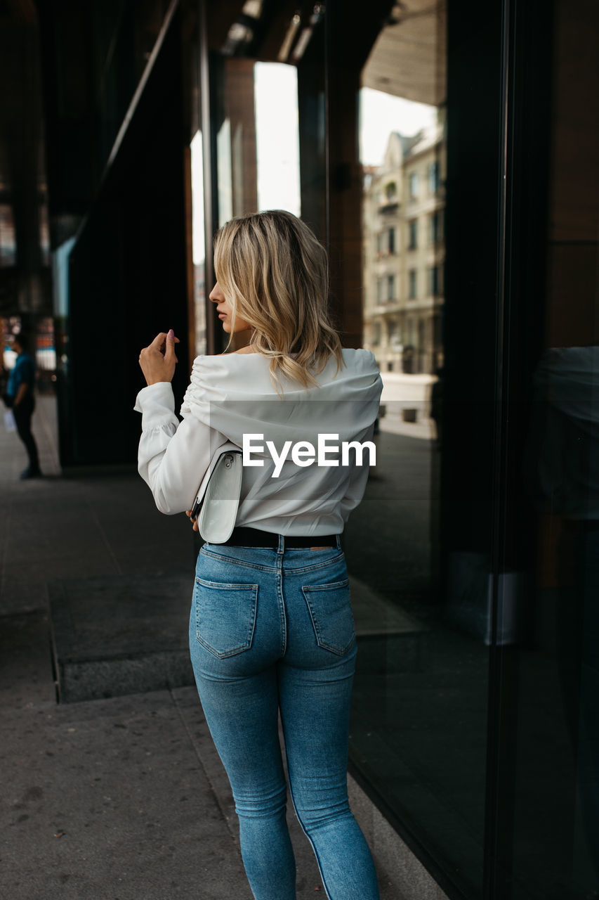 WOMAN STANDING IN FRONT OF A BUILDING