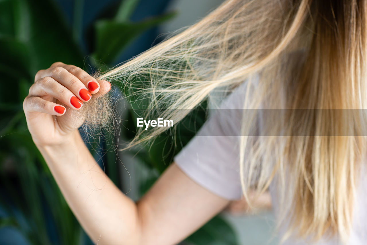 one person, women, adult, blond hair, close-up, green, hand, grass, nature, long hair, hairstyle, holding, plant, young adult, nail polish, flower, outdoors, summer, crop, human hair, agriculture, female, day, nail, spring, skin