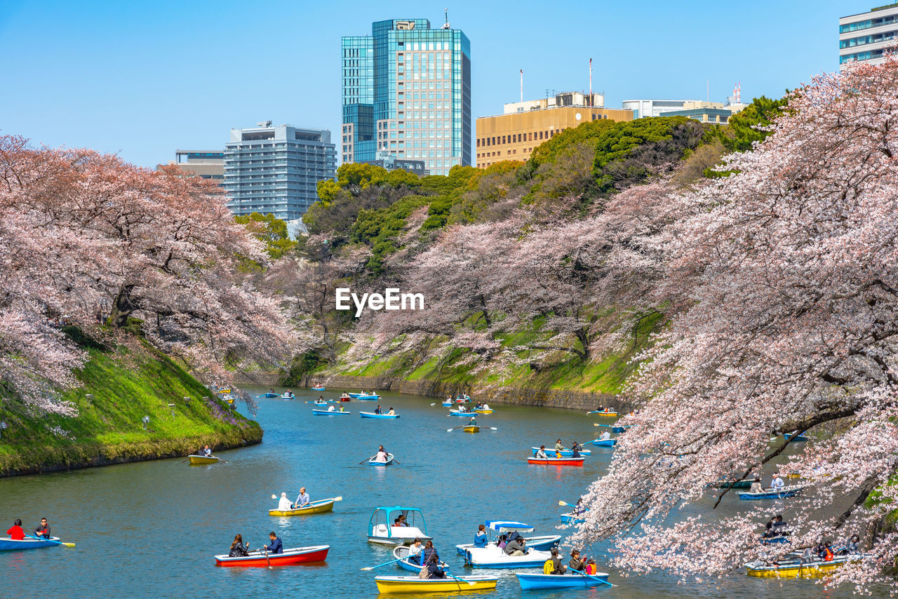 Boats in river amidst mountains against buildings