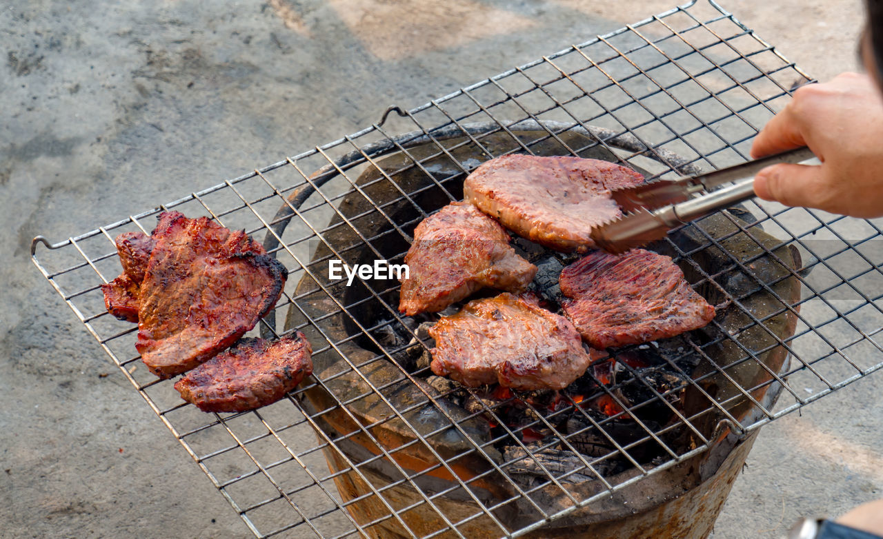 MEAT COOKING ON BARBECUE GRILL