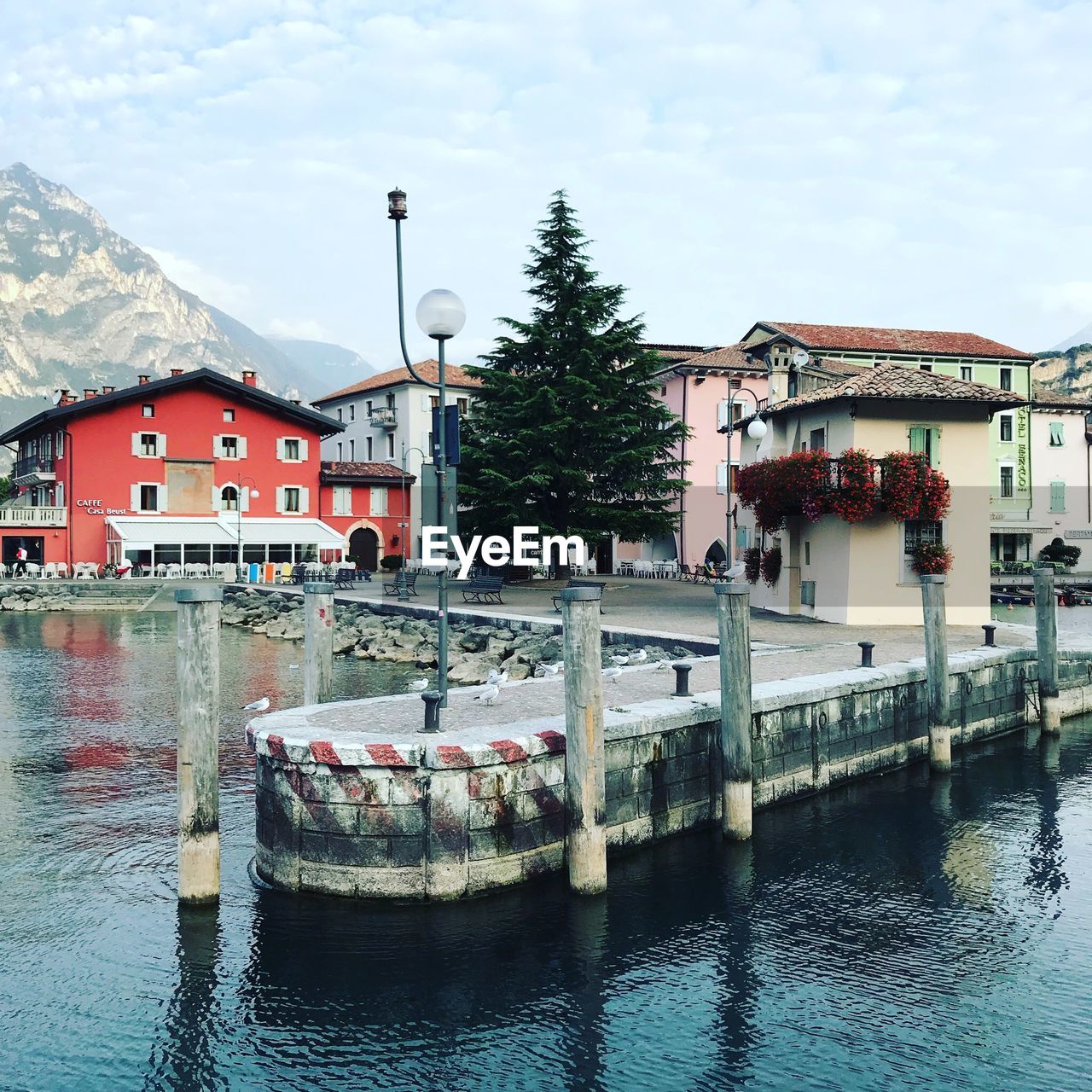 Houses by river against sky in city