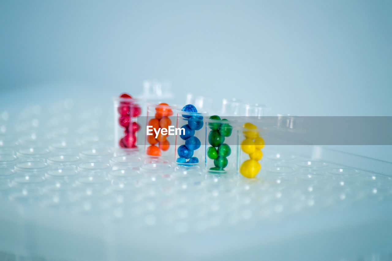 studio shot, indoors, no people, blue, healthcare and medicine, large group of objects, multi colored, pill, medicine, selective focus, variation, capsule, close-up, copy space, still life, science, dose, colored background, research, in a row, group of objects