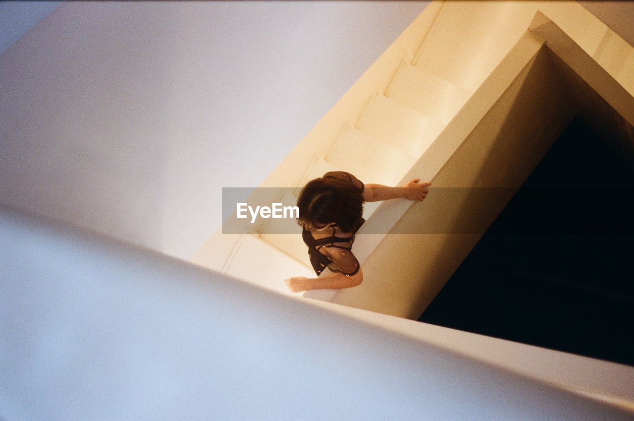 Directly above shot of woman standing on steps in building