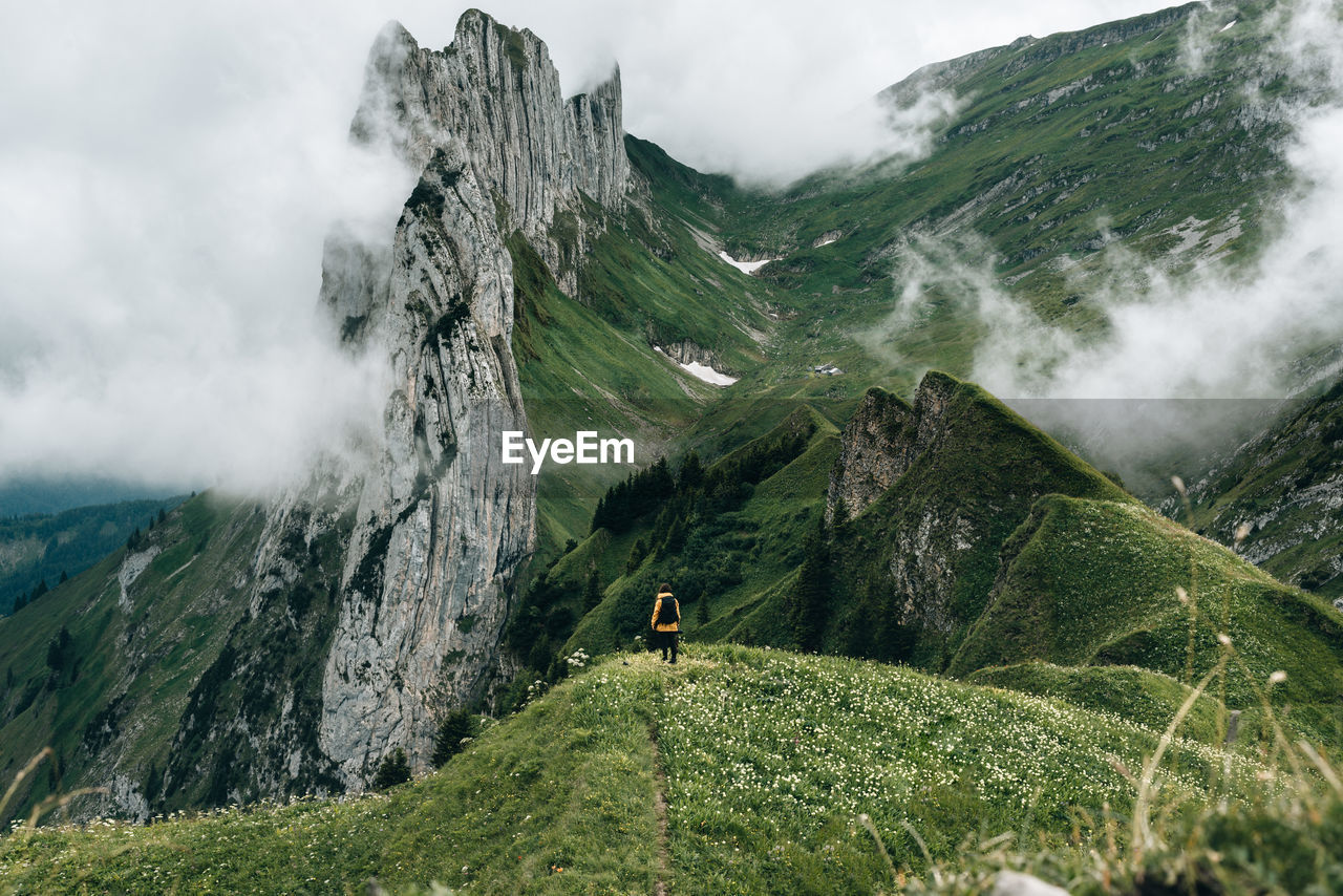 Rear view of man on mountain against sky