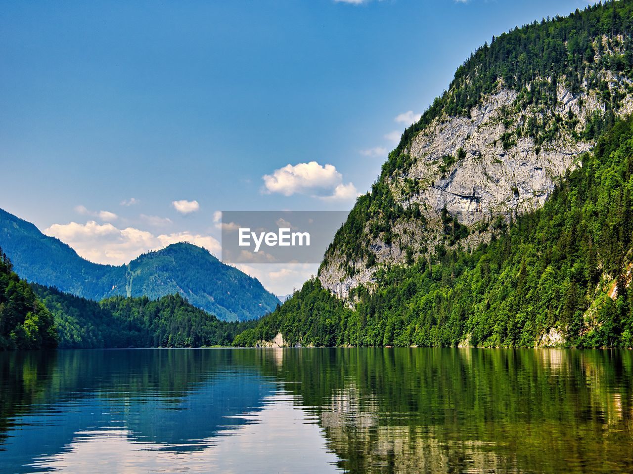 scenic view of lake by mountain against sky