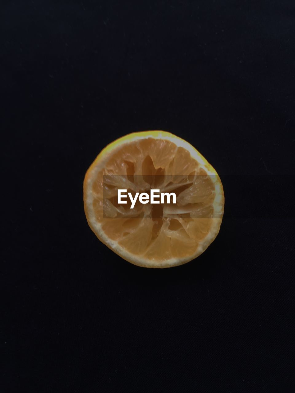 CLOSE-UP OF LEMON OVER BLACK BACKGROUND