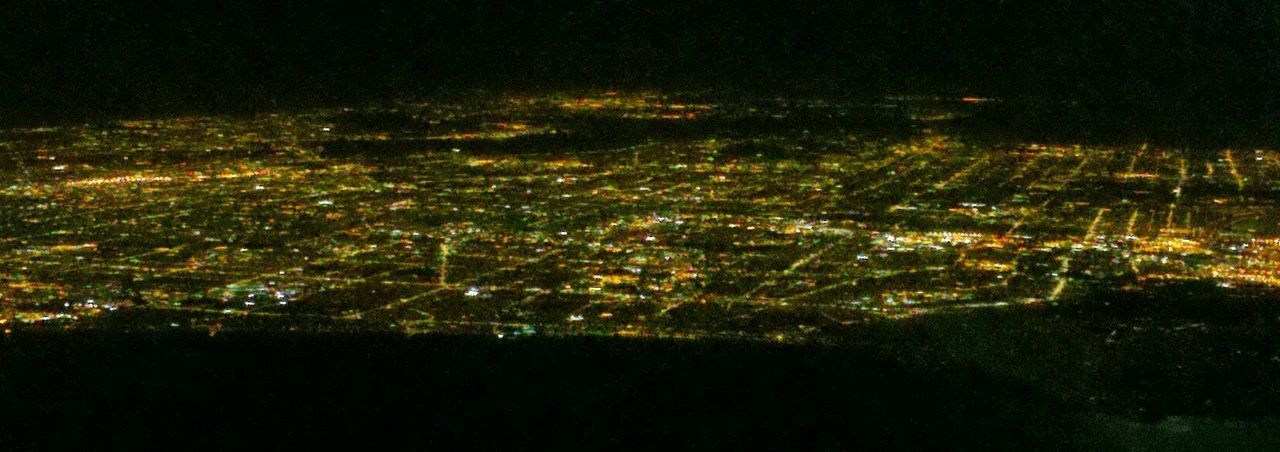 VIEW OF ILLUMINATED CITYSCAPE AT NIGHT