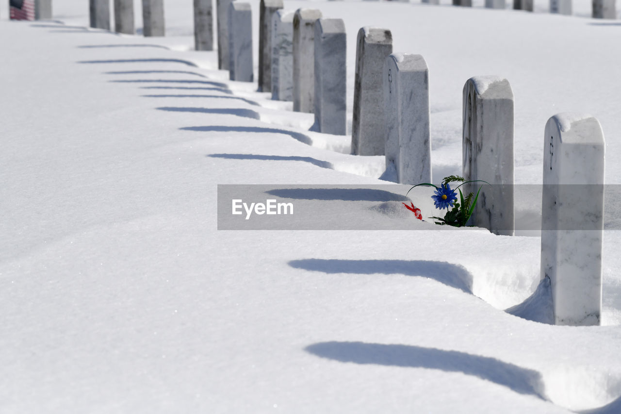 Graveyard markers in a row under snow covering