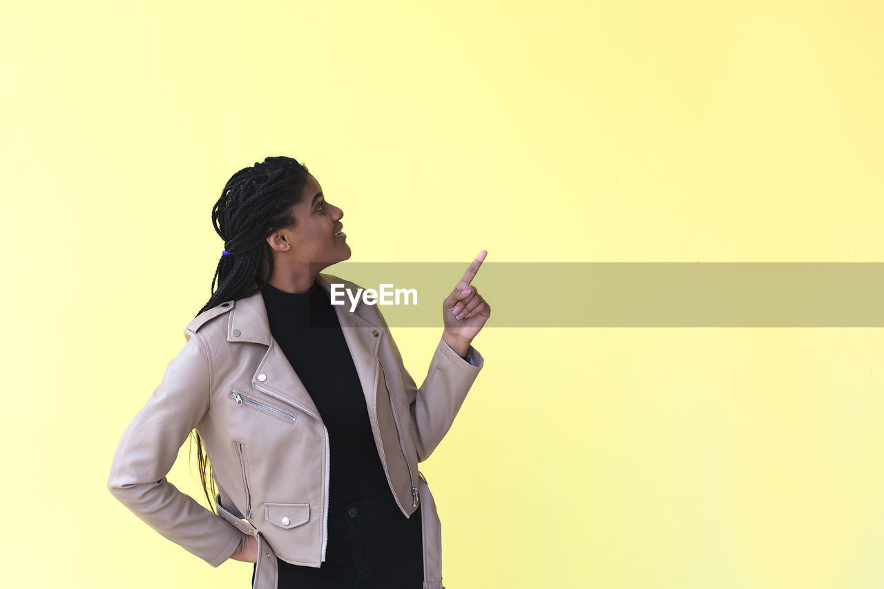 YOUNG WOMAN WEARING MASK AGAINST WHITE BACKGROUND