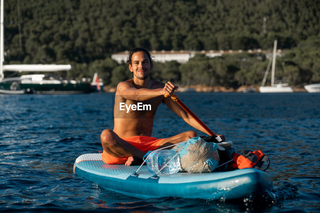 Portrait of shirtless man in boat