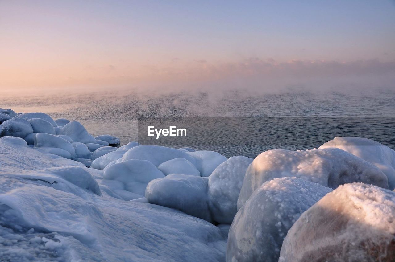 Scenic view of frozen sea against sky during sunset