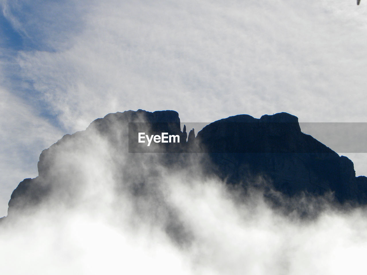 LOW ANGLE VIEW OF CLOUDS AND MOUNTAIN AGAINST SKY