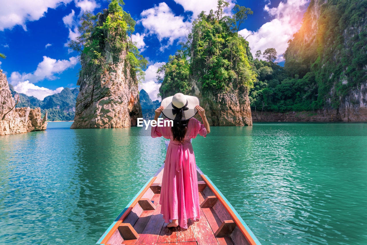 Rear view of woman standing in boat on sea