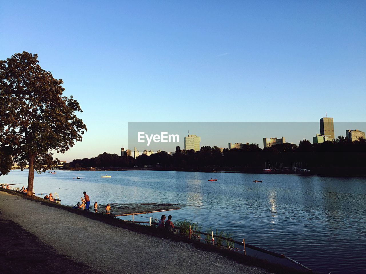 SCENIC VIEW OF RIVER BY CITY AGAINST CLEAR SKY