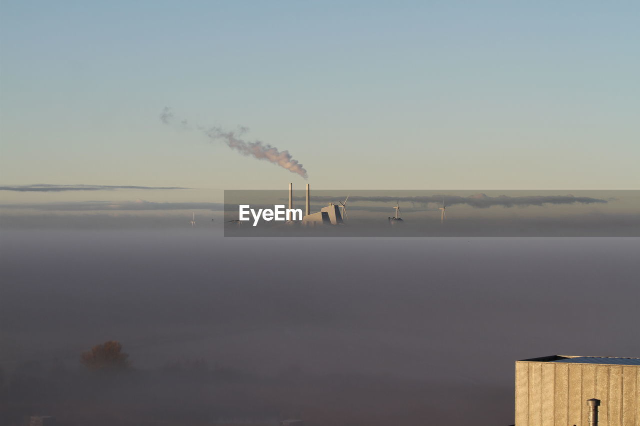 Smoke emitting from chimney against sky