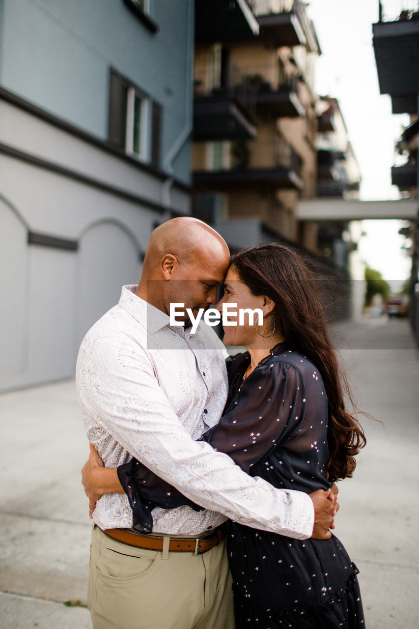 Late forties couple embracing in alley in san diego