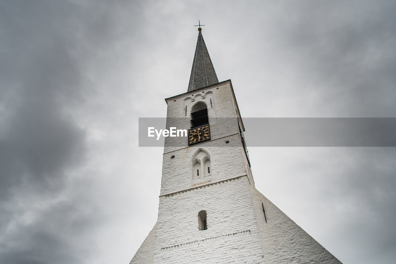 LOW ANGLE VIEW OF CLOCK TOWER AMIDST BUILDINGS AGAINST SKY