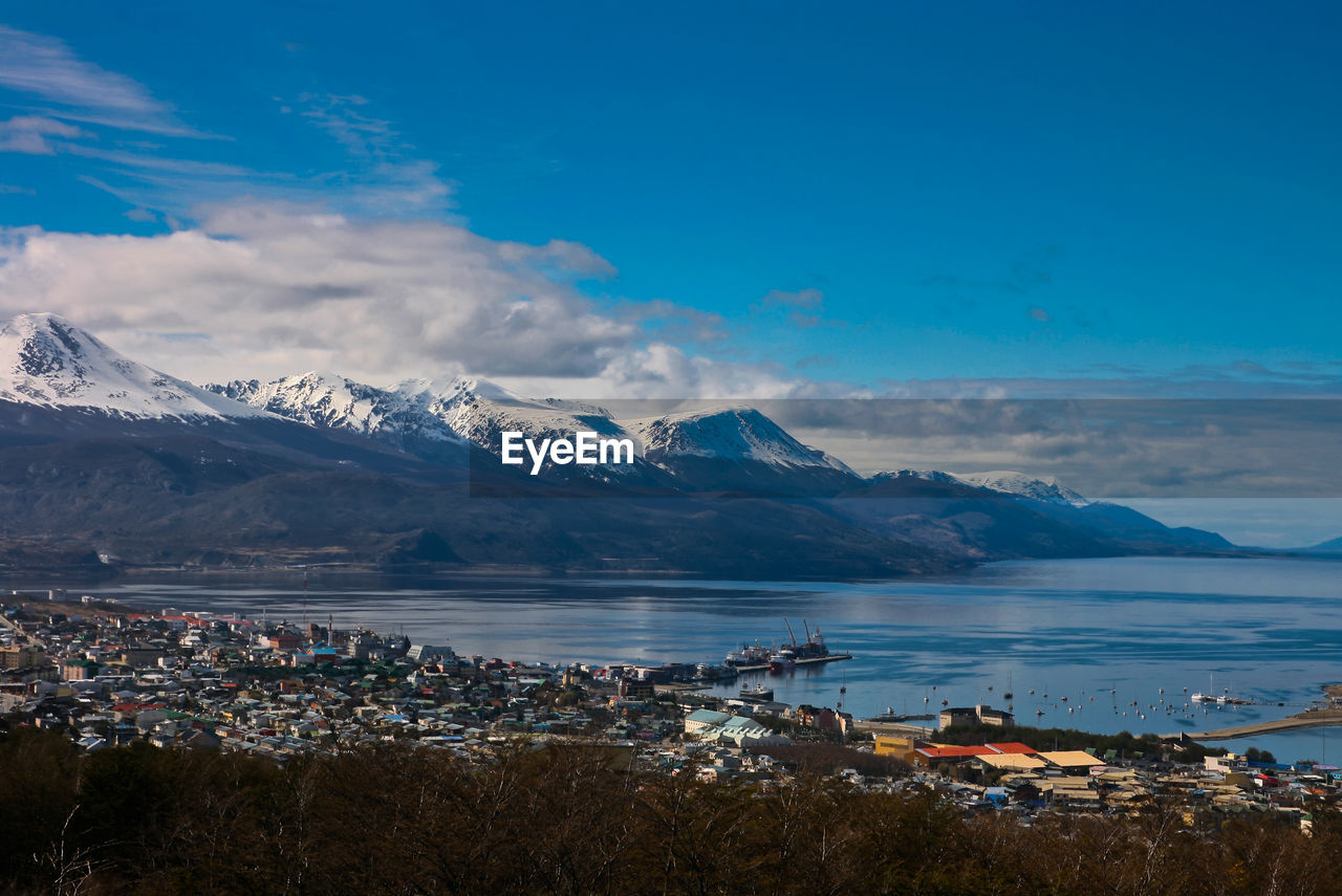 Scenic view of sea by mountain against sky